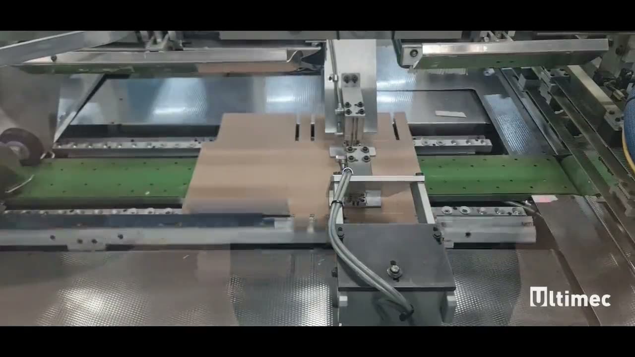 Een kartonnen blank wordt om het product heen gevouwen terwijl de lijn draait.